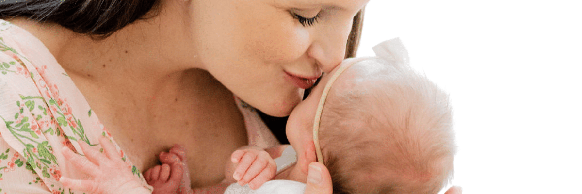 mom kissing newborn baby forehead